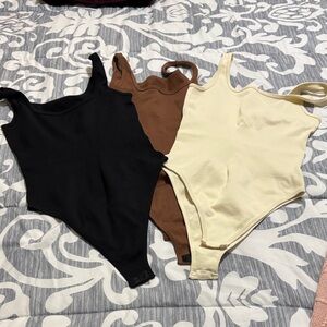 Set of Three Ribbed Bodysuits in Black, Brown, and Cream